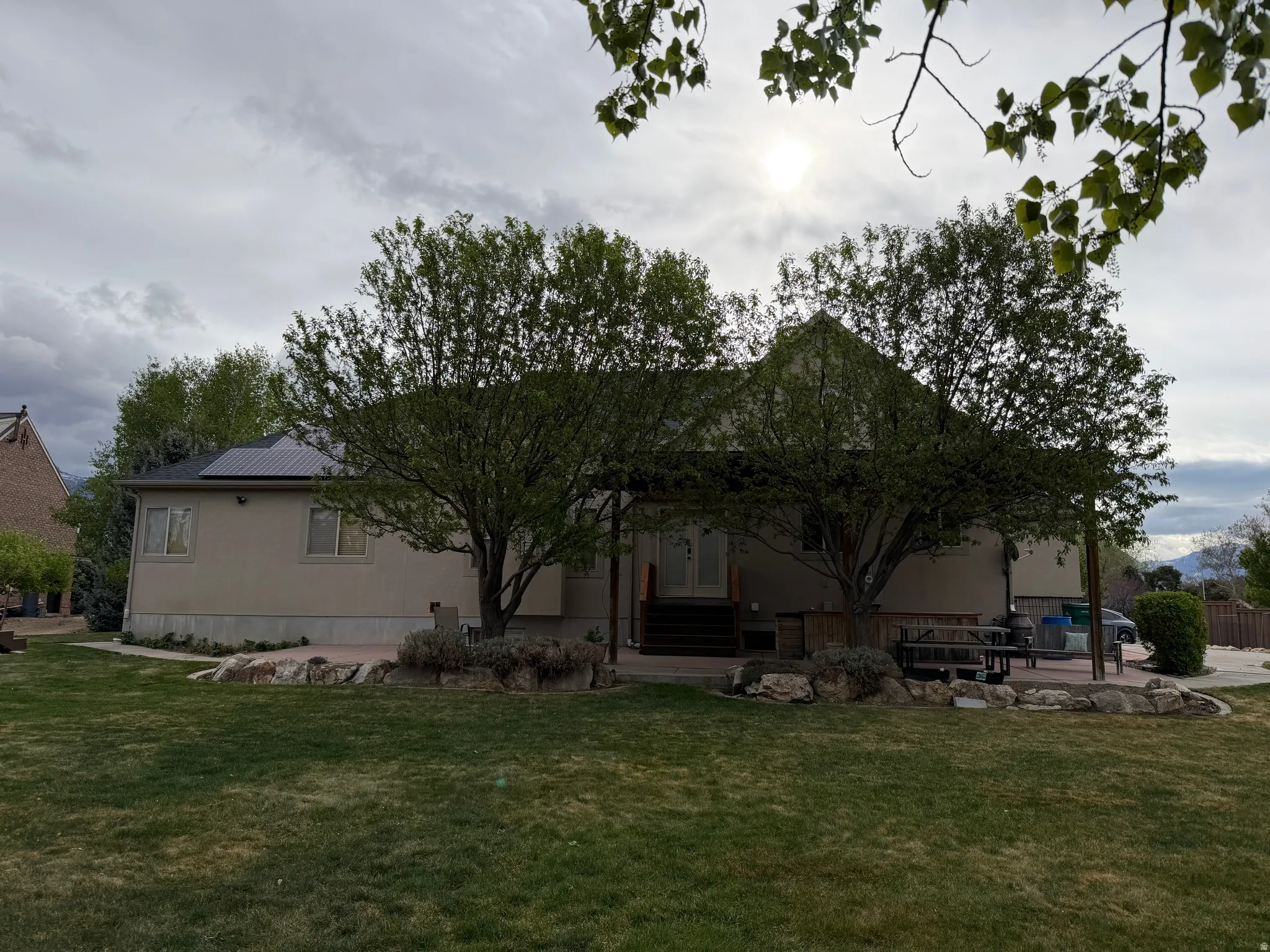 Back of house with a yard, a patio, and a metal roof