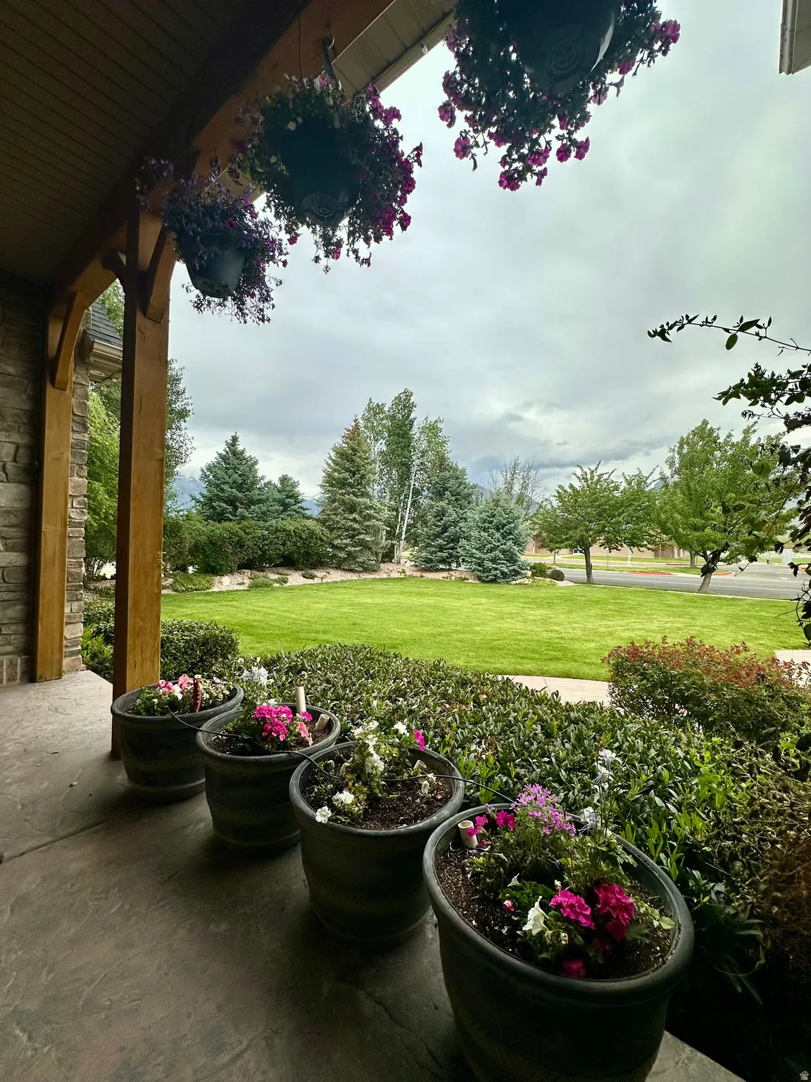 Covered porch with exposed wood beams, stone accents and mountain views.