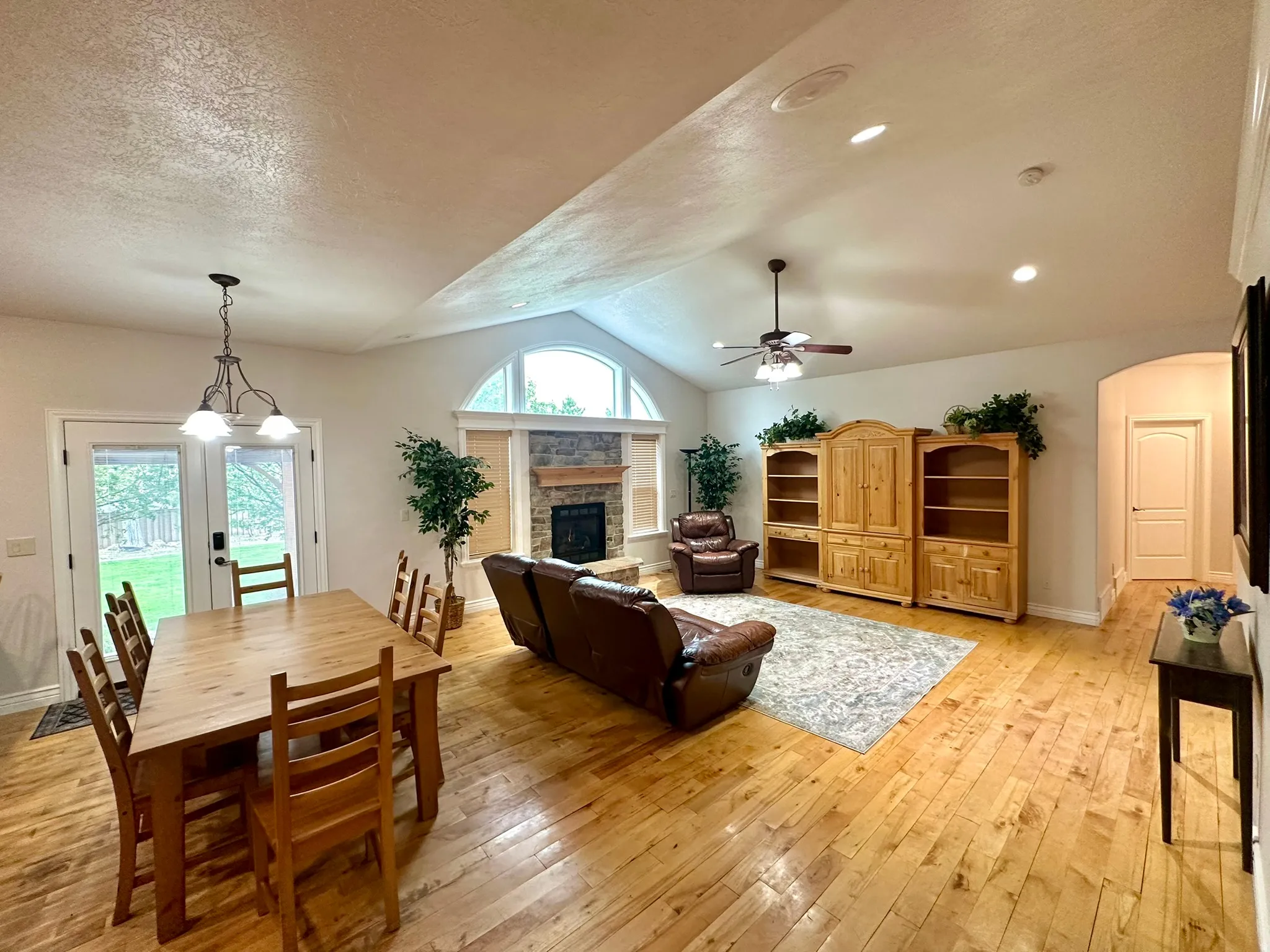 Vaulted ceilings define this open-concept room featuring hard wood flooring throughout