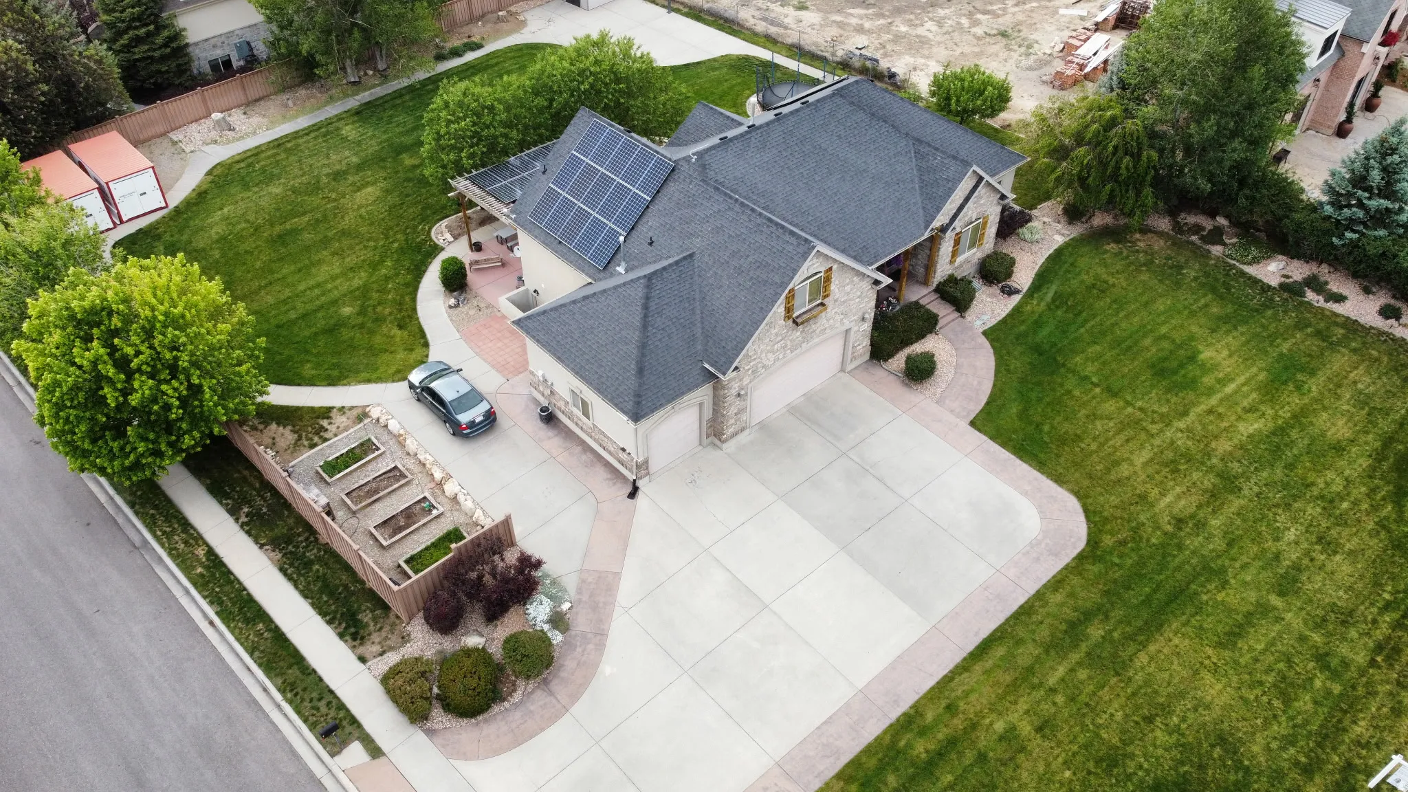 Stately residence featuring a stone and siding exterior, a dark shingle roof, and solar panels