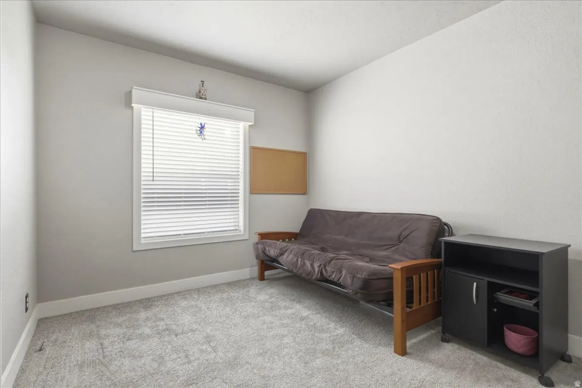 Living area featuring light colored carpet and baseboards