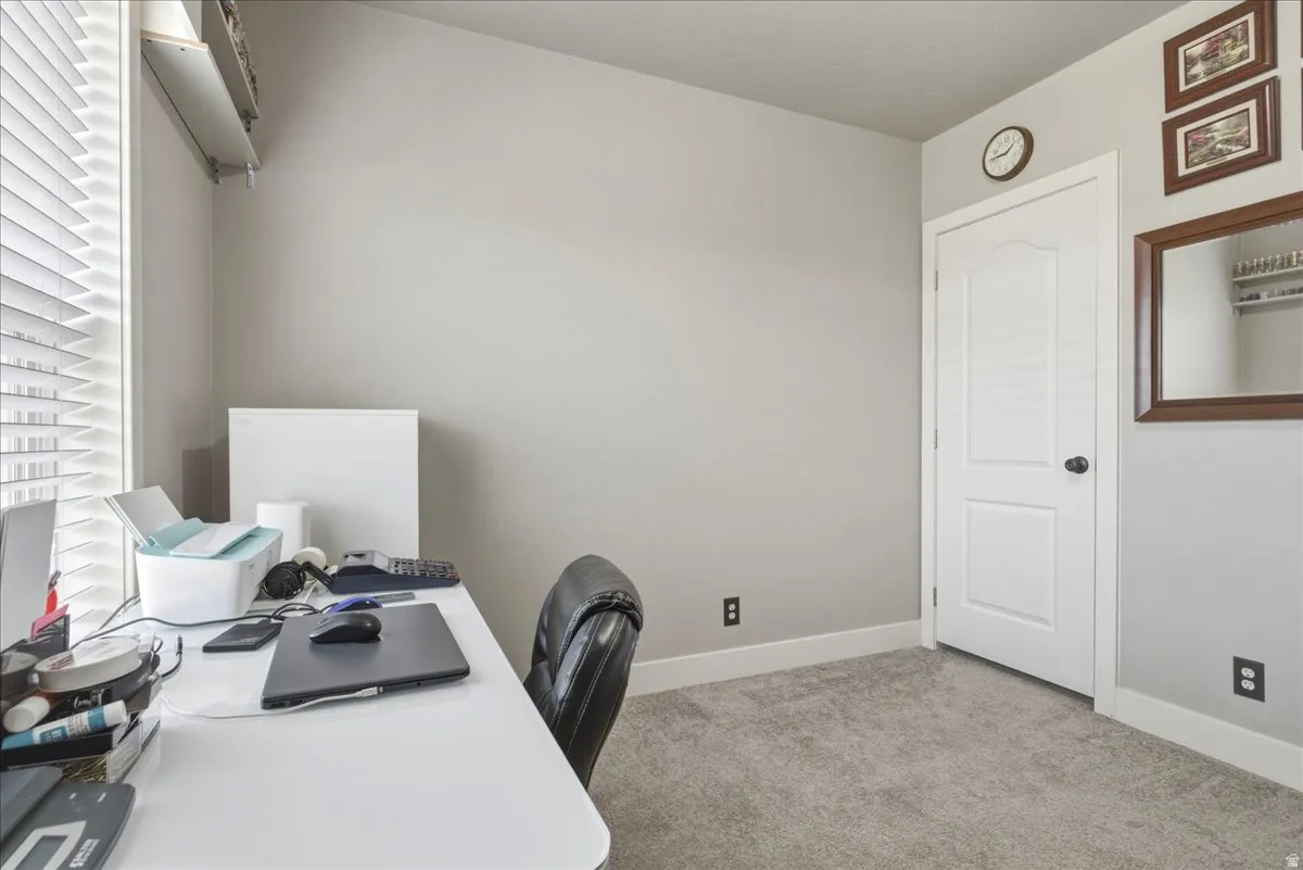 Office space with light carpet and baseboards
