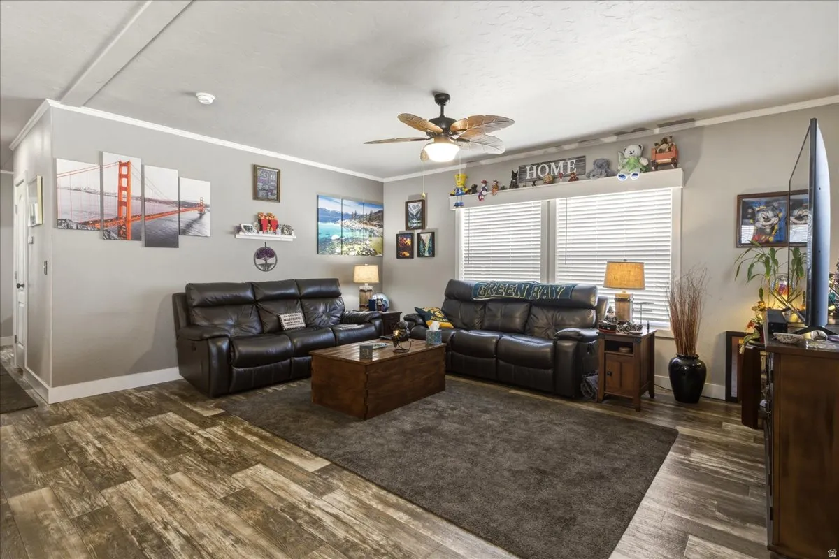 Living area featuring ornamental molding, a ceiling fan, and wood finished floors