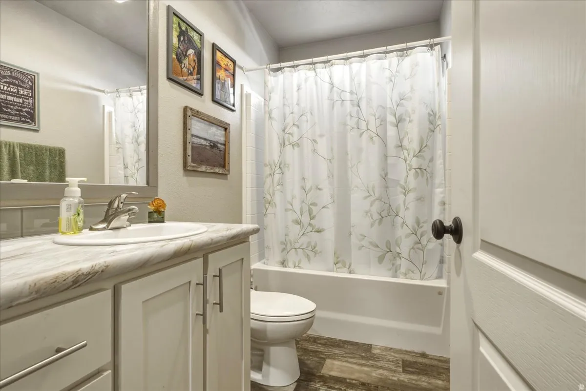 Full bathroom featuring vanity, dark wood-style flooring, and shower / bath combo