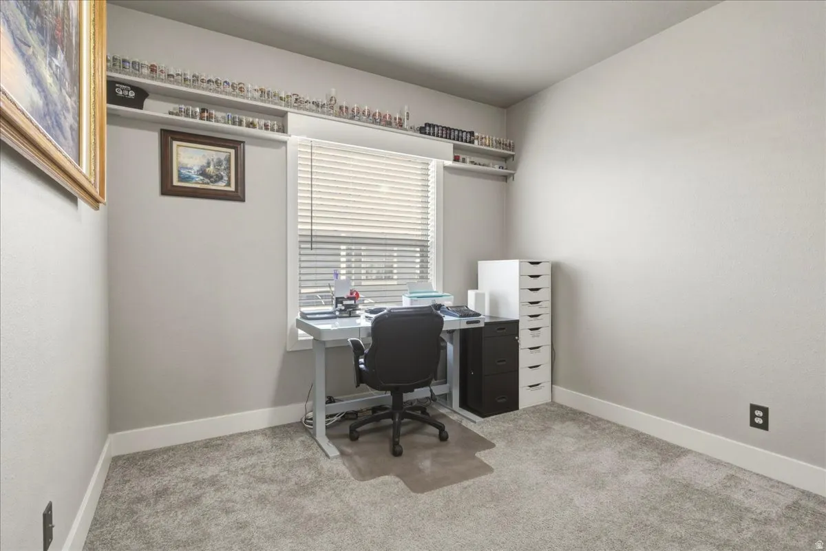 Home office featuring light colored carpet and baseboards