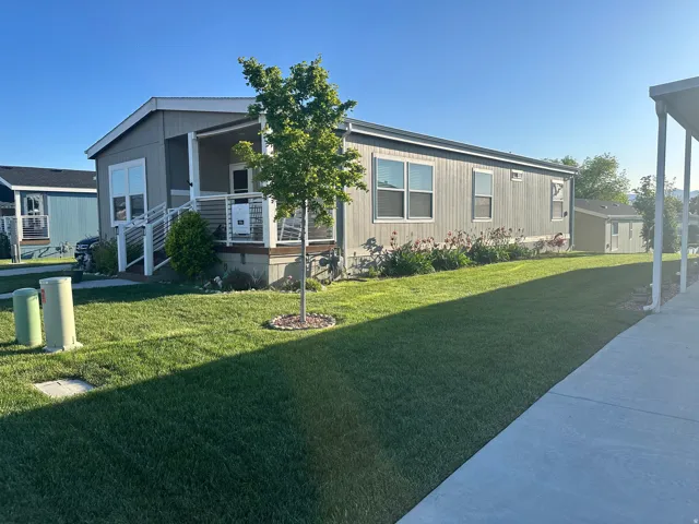 Gray siding exterior with multiple windows, an inviting covered porch, and a dedicated entry ramp