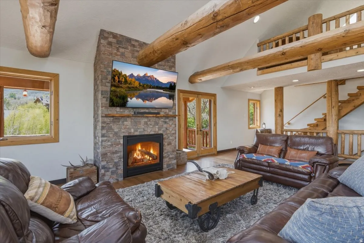 Living room featuring wood finished floors and a stone fireplace