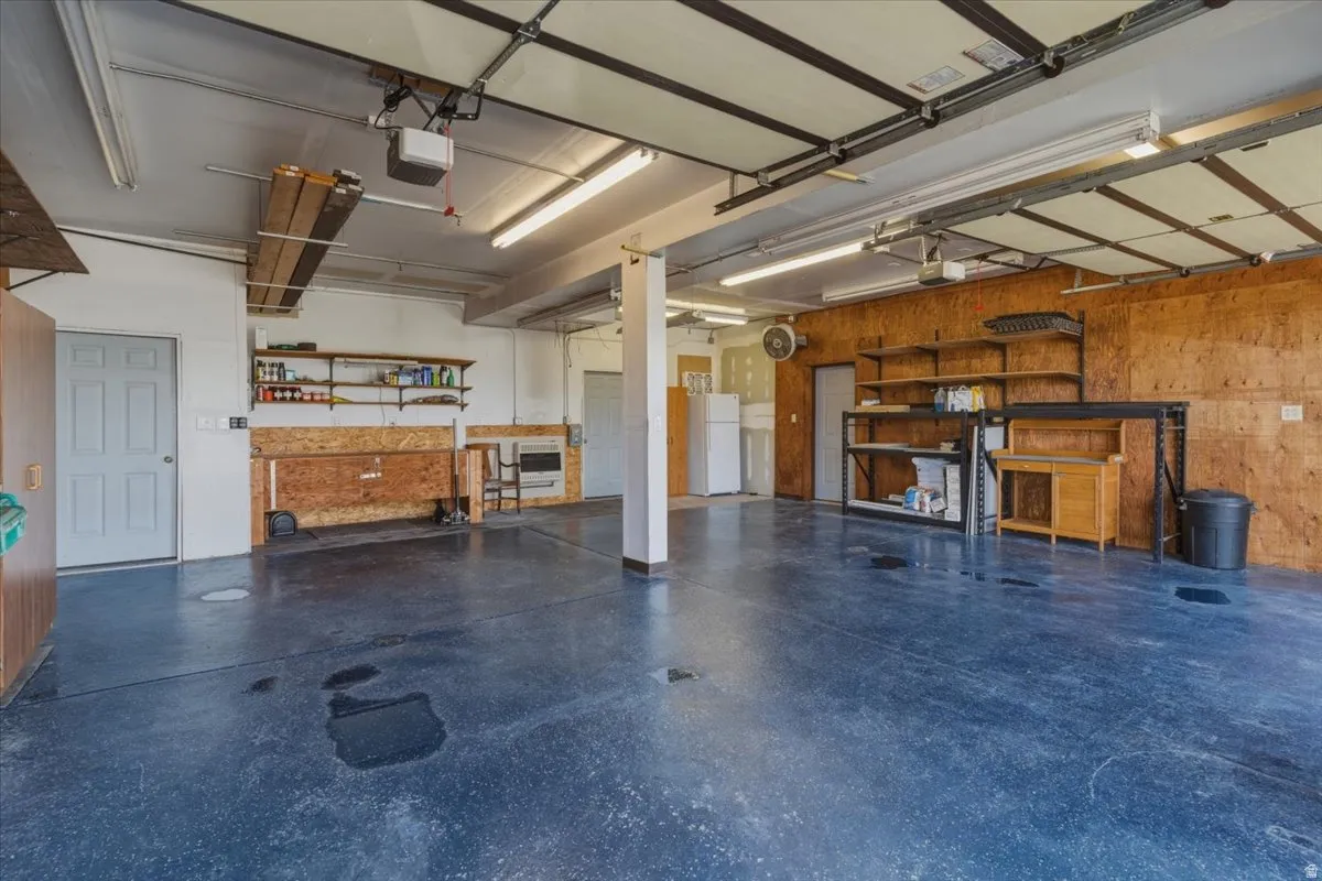 Garage with wooden walls and freestanding refrigerator