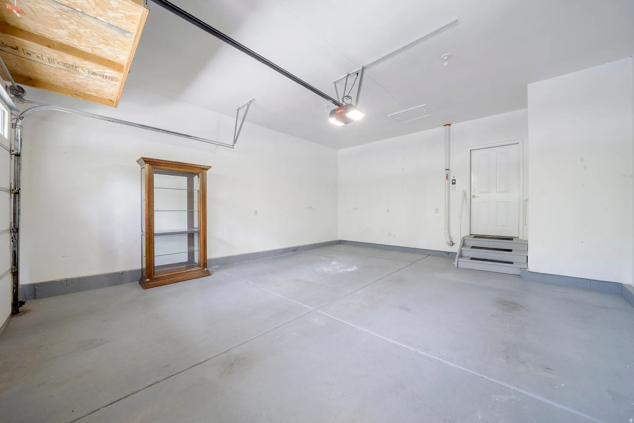 Garage with baseboards and a garage door opener