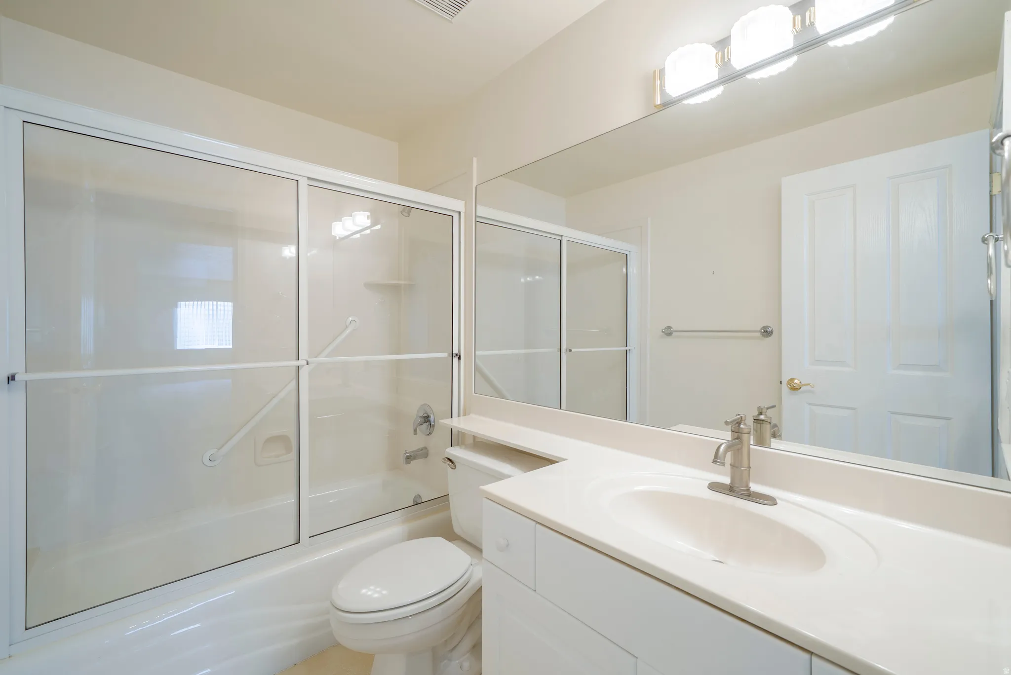 Bathroom featuring vanity and enclosed tub / shower combo