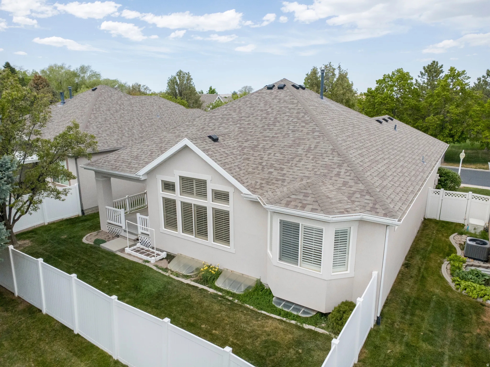 Back of house featuring a fenced backyard, a shingled roof, and stucco siding