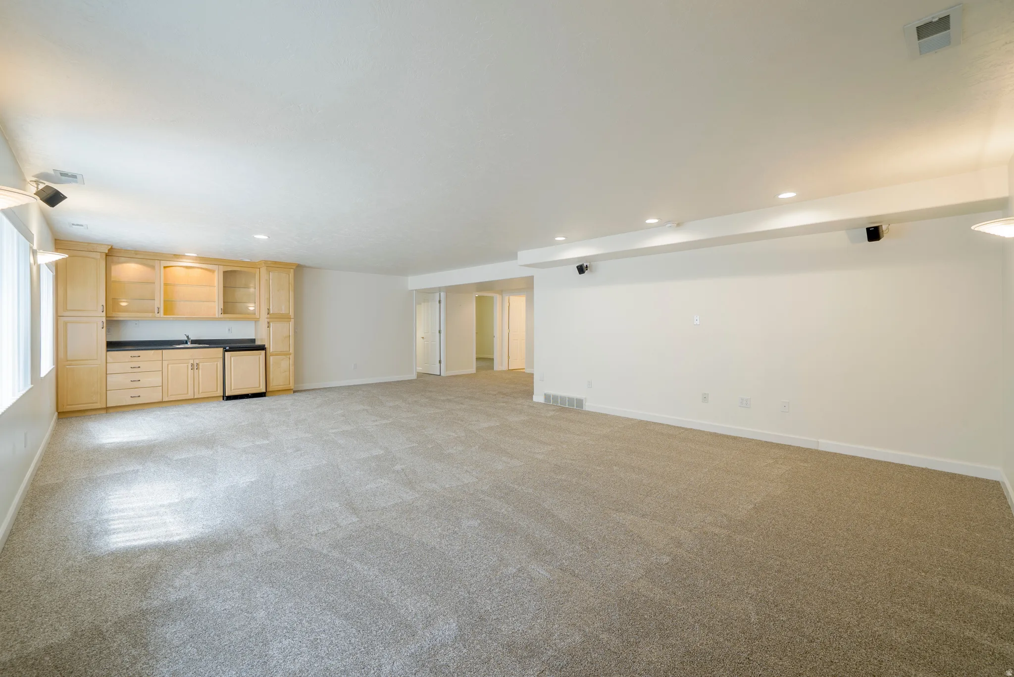 Unfurnished living room featuring light colored carpet and recessed lighting