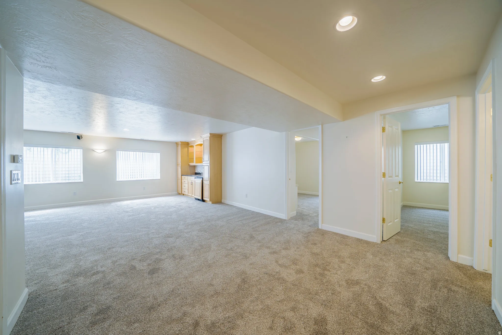 Unfurnished living room featuring light carpet and recessed lighting