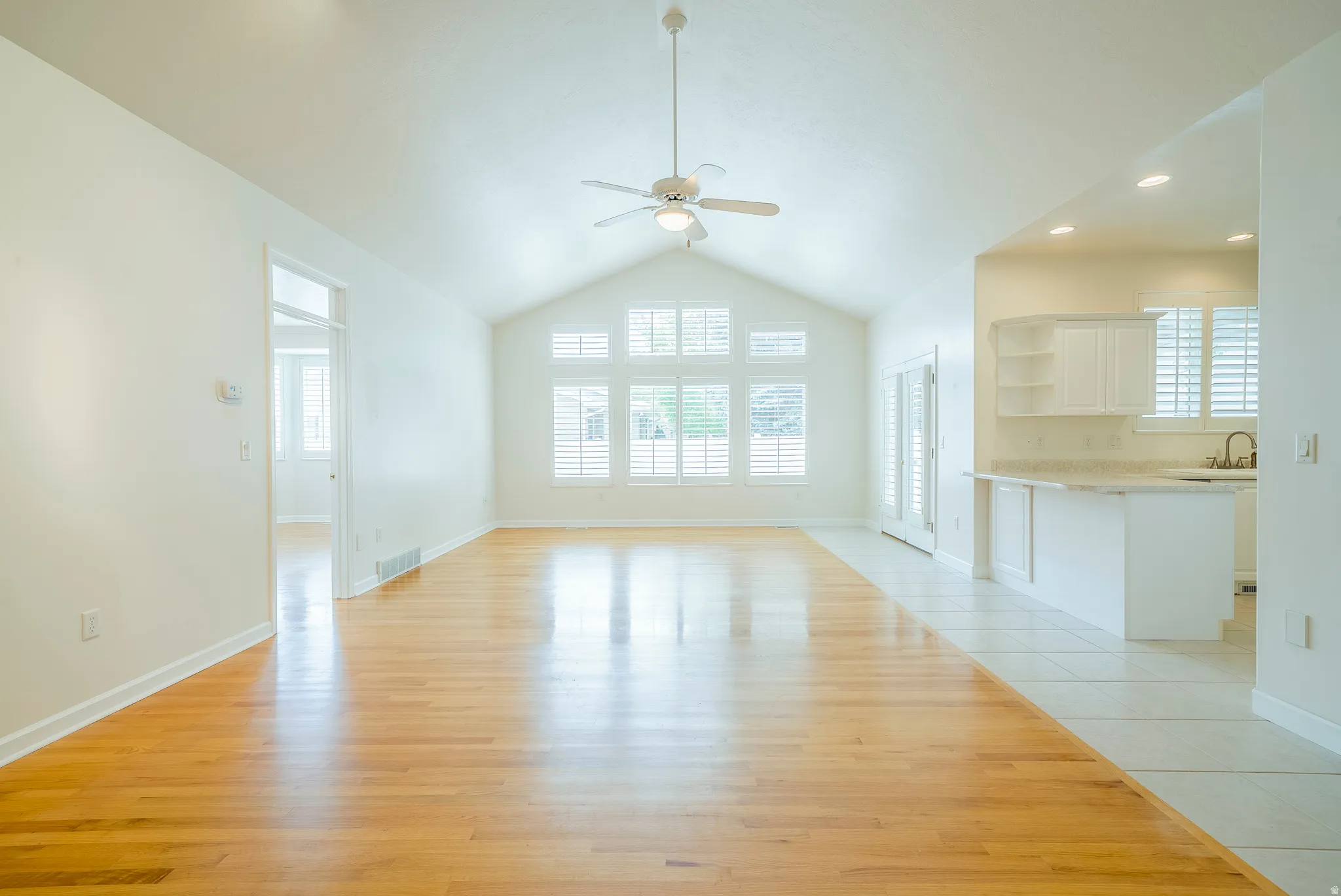 Unfurnished living room with light wood-type flooring and ceiling fan