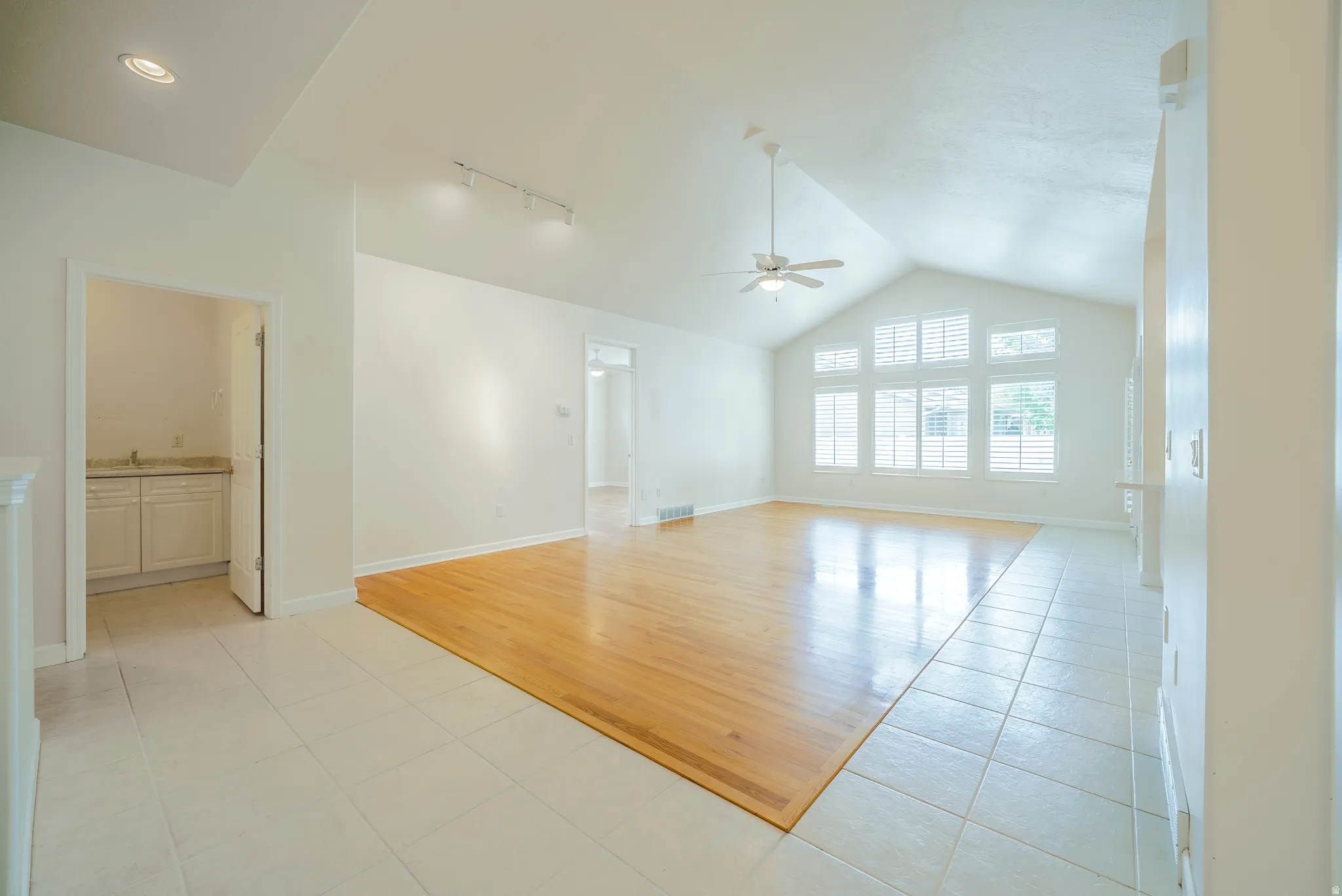 Unfurnished room featuring light tile patterned floors, ceiling fan, and track lighting