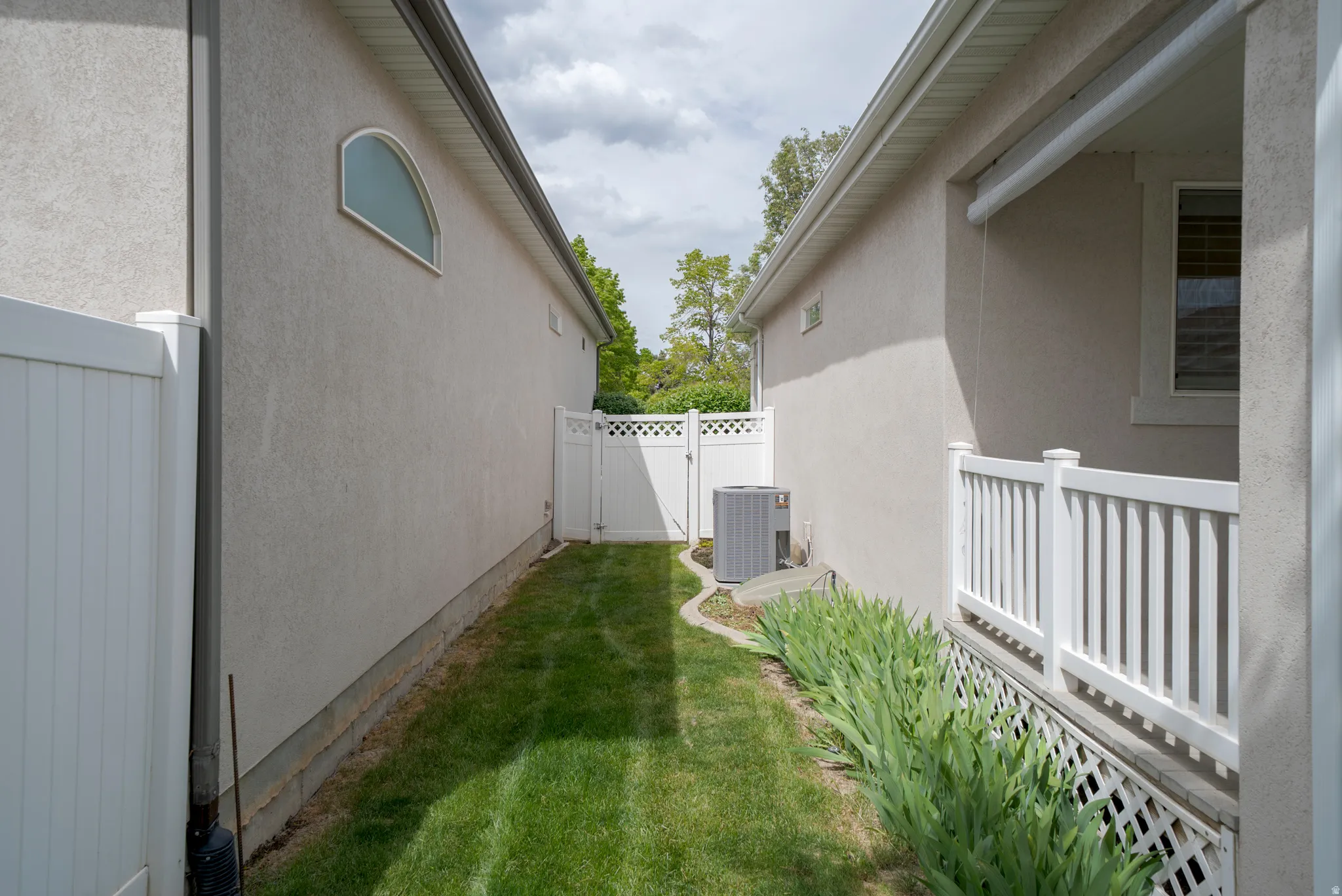 View of property exterior featuring a gate and stucco siding