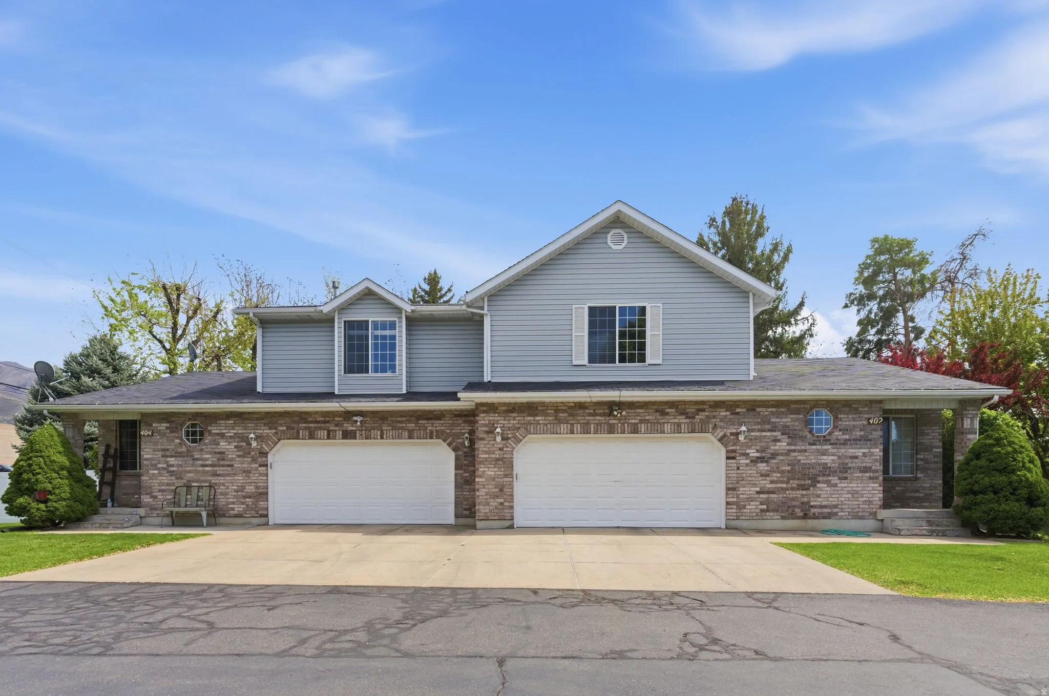 Traditional home with a garage, concrete driveway, and brick siding