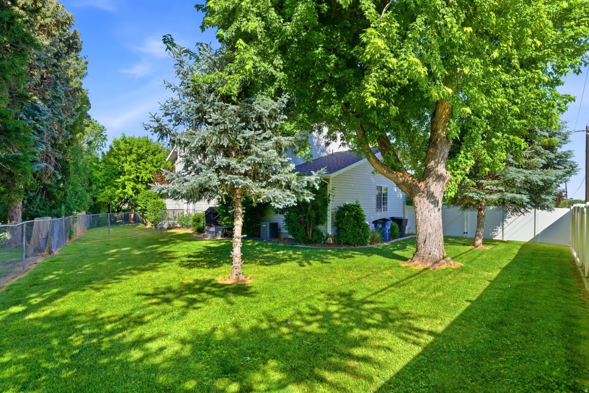 Expansive green lawn with mature trees providing ample shade