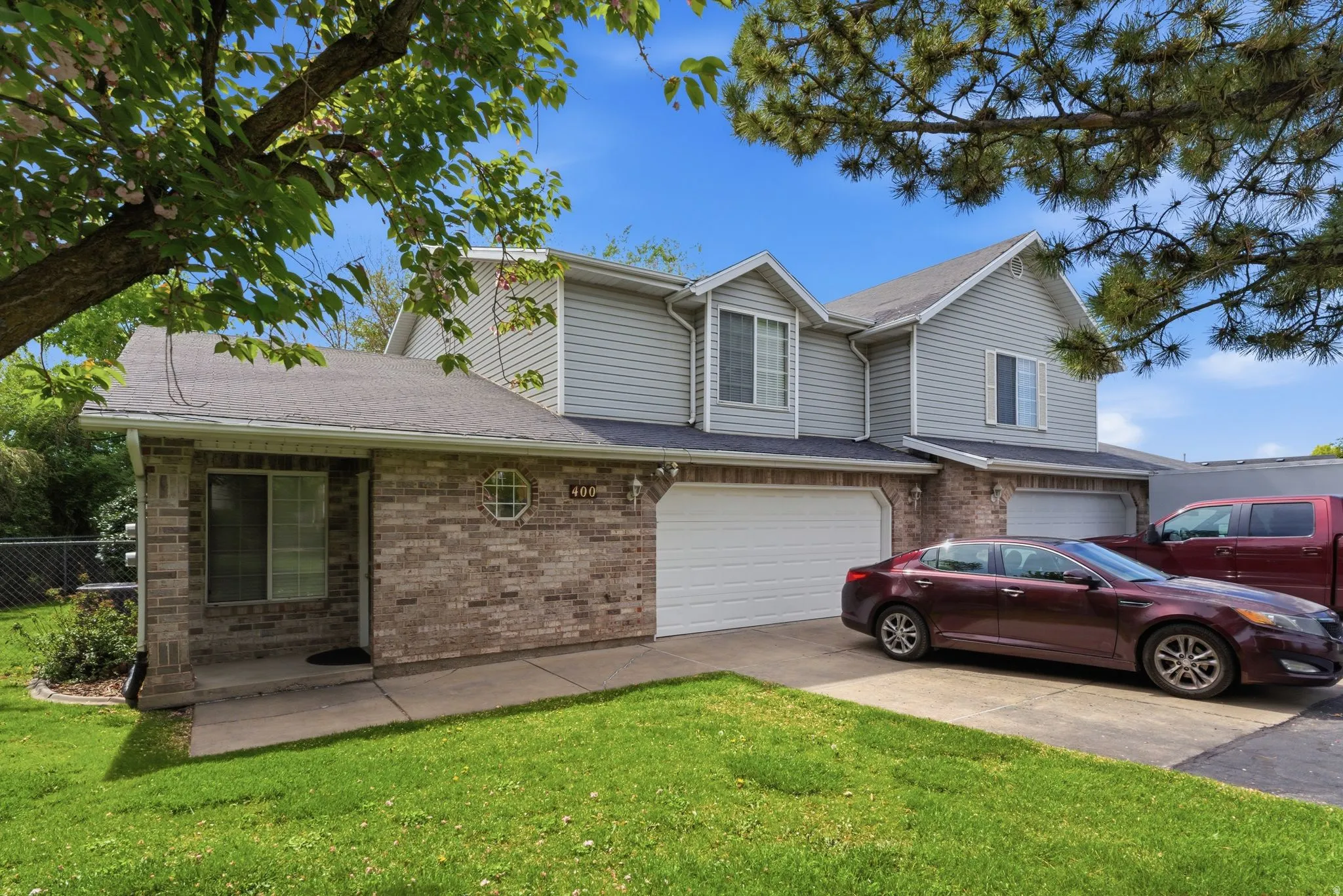 Traditional home with brick siding, driveway, an attached garage, and roof with shingles