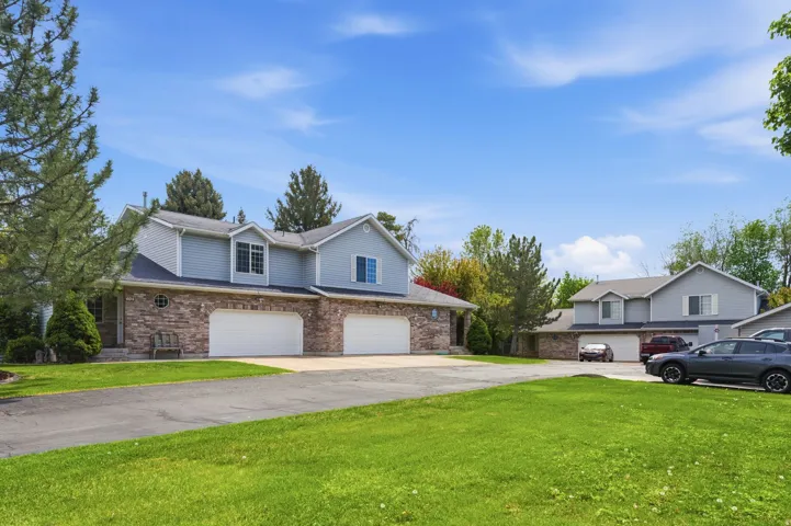 Traditional home featuring a front lawn, a garage, concrete driveway, and brick siding