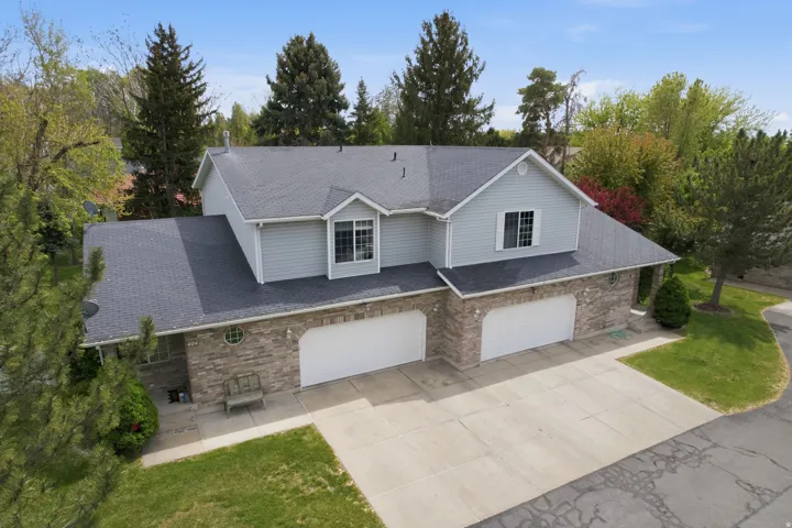 Traditional-style home with a garage, driveway, a front yard, and brick siding