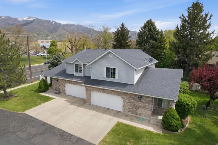 Traditional-style house with a garage, driveway, brick siding, and a mountain view