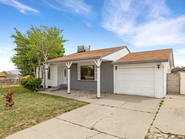 View of front of property featuring driveway, a garage, a shingled roof, and brick siding
