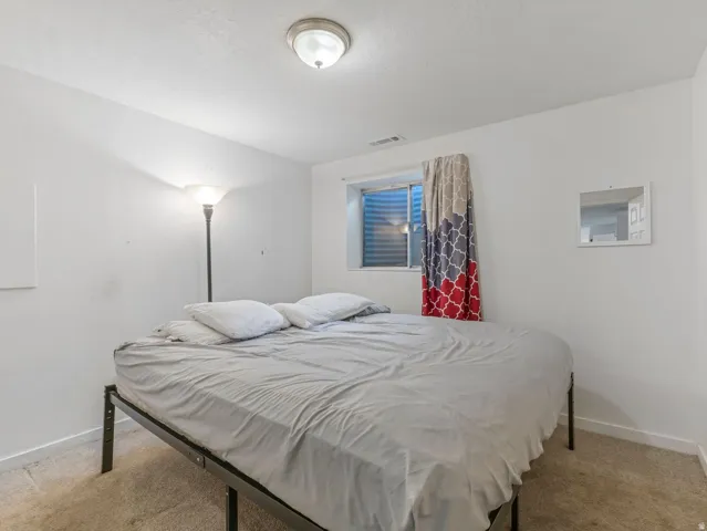 Bedroom featuring baseboards and light colored carpet