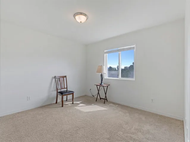 Living area featuring light carpet and baseboards