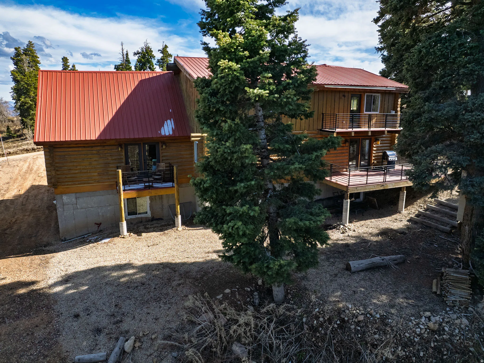 Back of property with a metal roof and a balcony