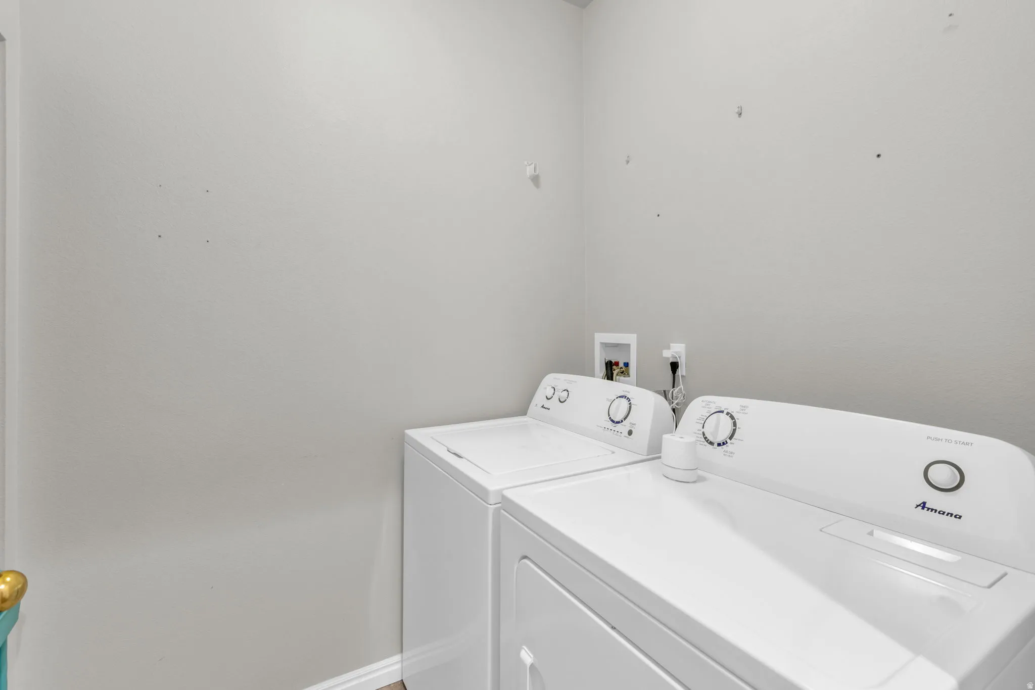 Laundry room featuring washing machine and clothes dryer and baseboards
