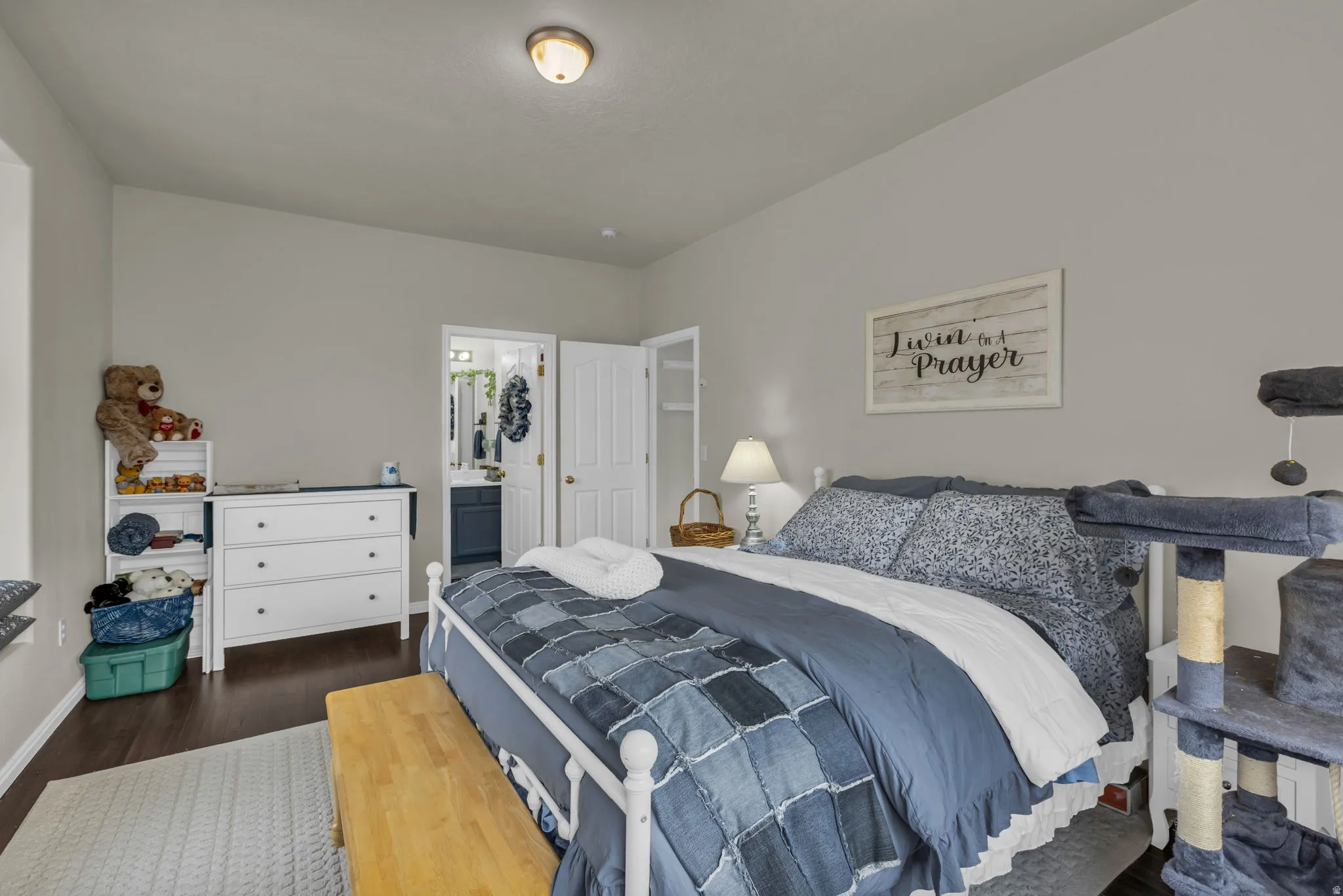 Bedroom with dark wood-style floors and connected bathroom