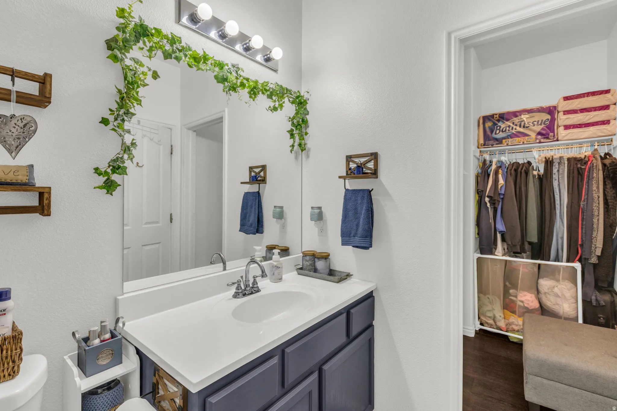 Bathroom with vanity, a spacious closet, and a textured wall