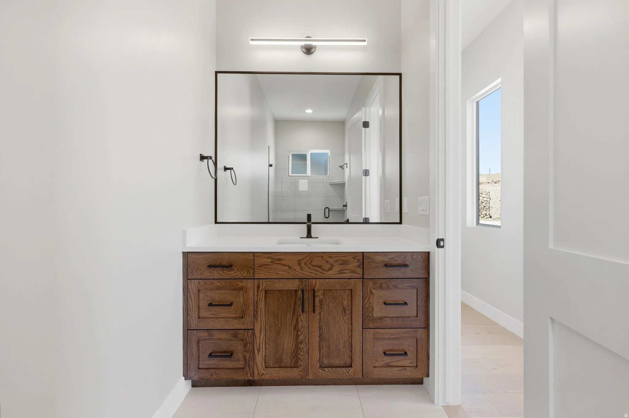 Bathroom with vanity, light tile patterned floors, a shower, and recessed lighting