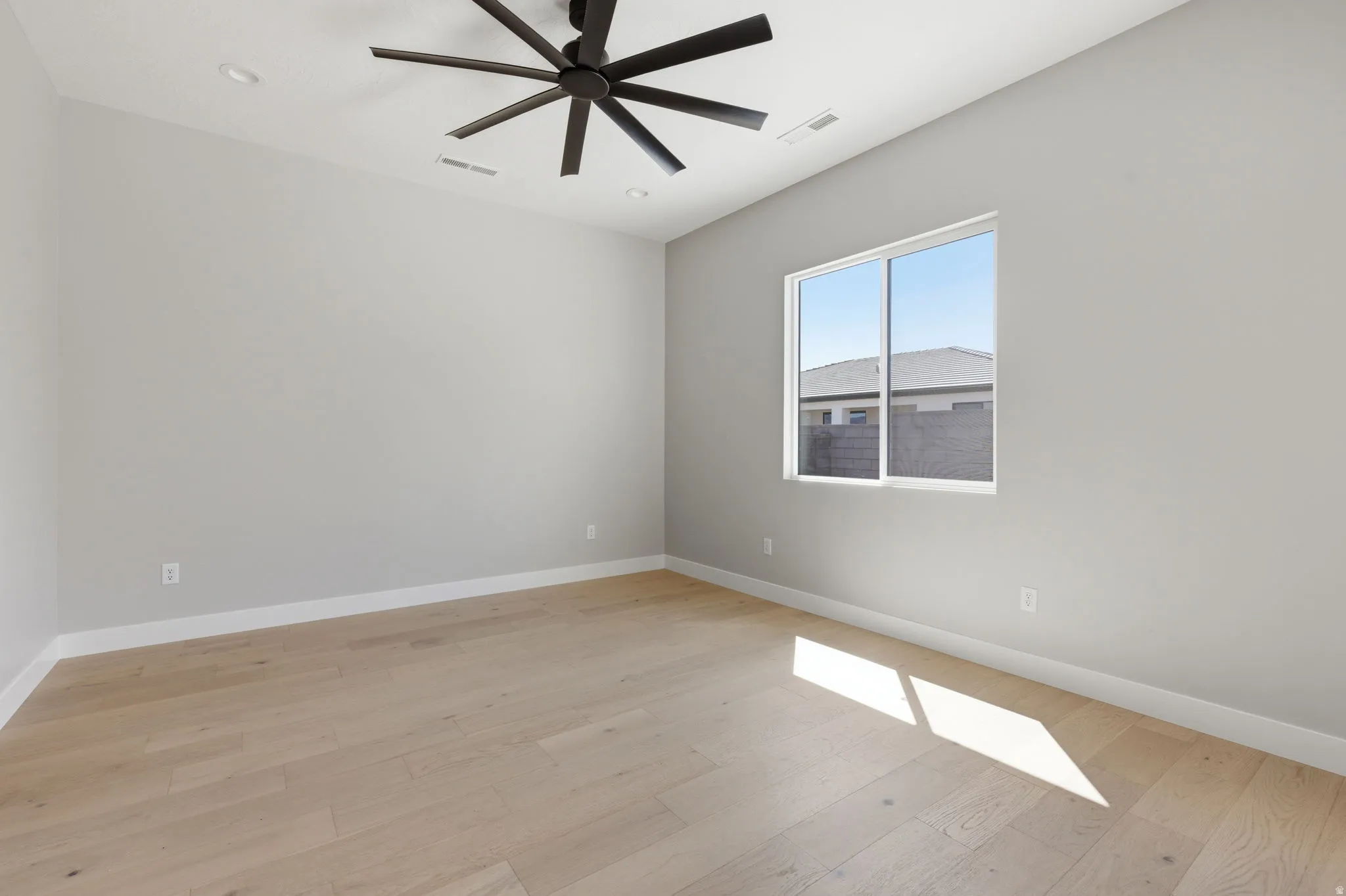 Empty room with light wood-type flooring, ceiling fan, and recessed lighting