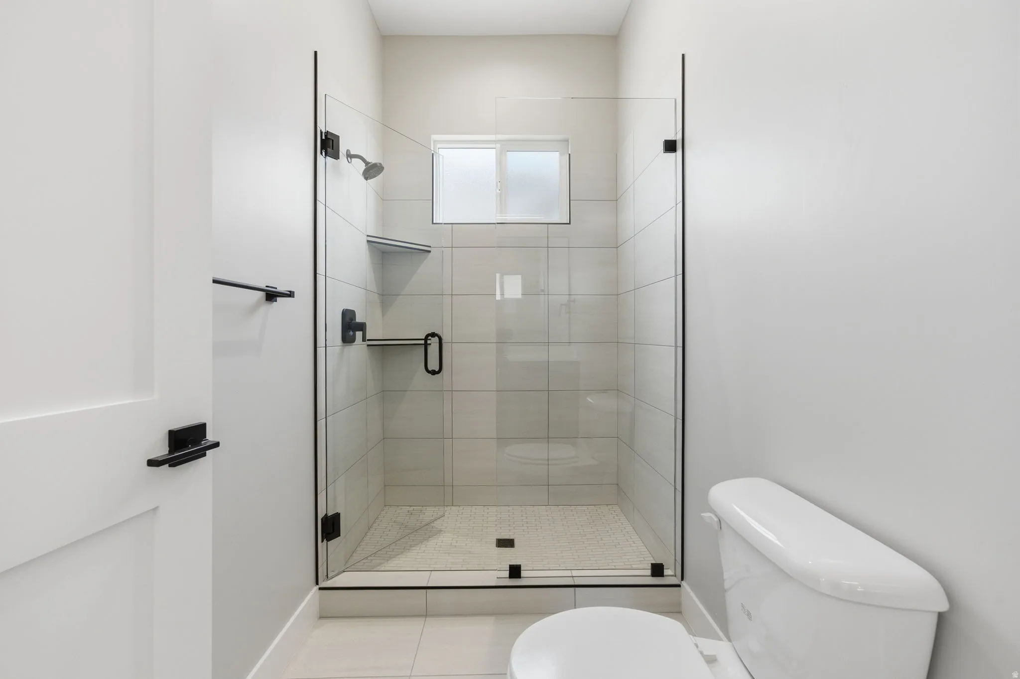 Full bath with a stall shower and light tile patterned floors