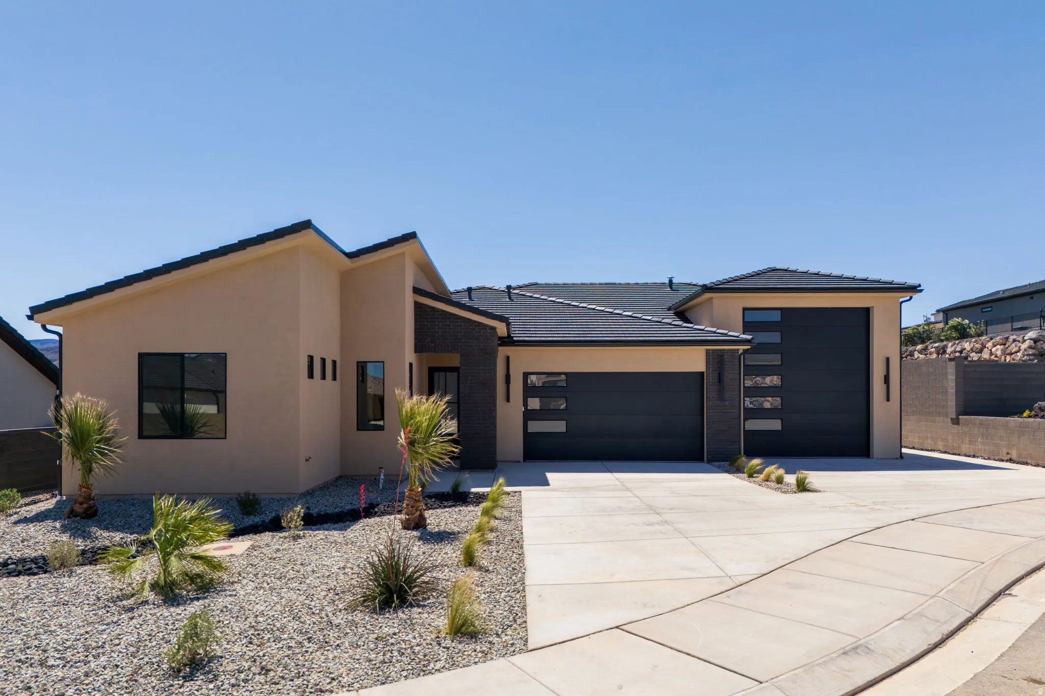 Contemporary home featuring an attached garage, driveway, and stucco siding