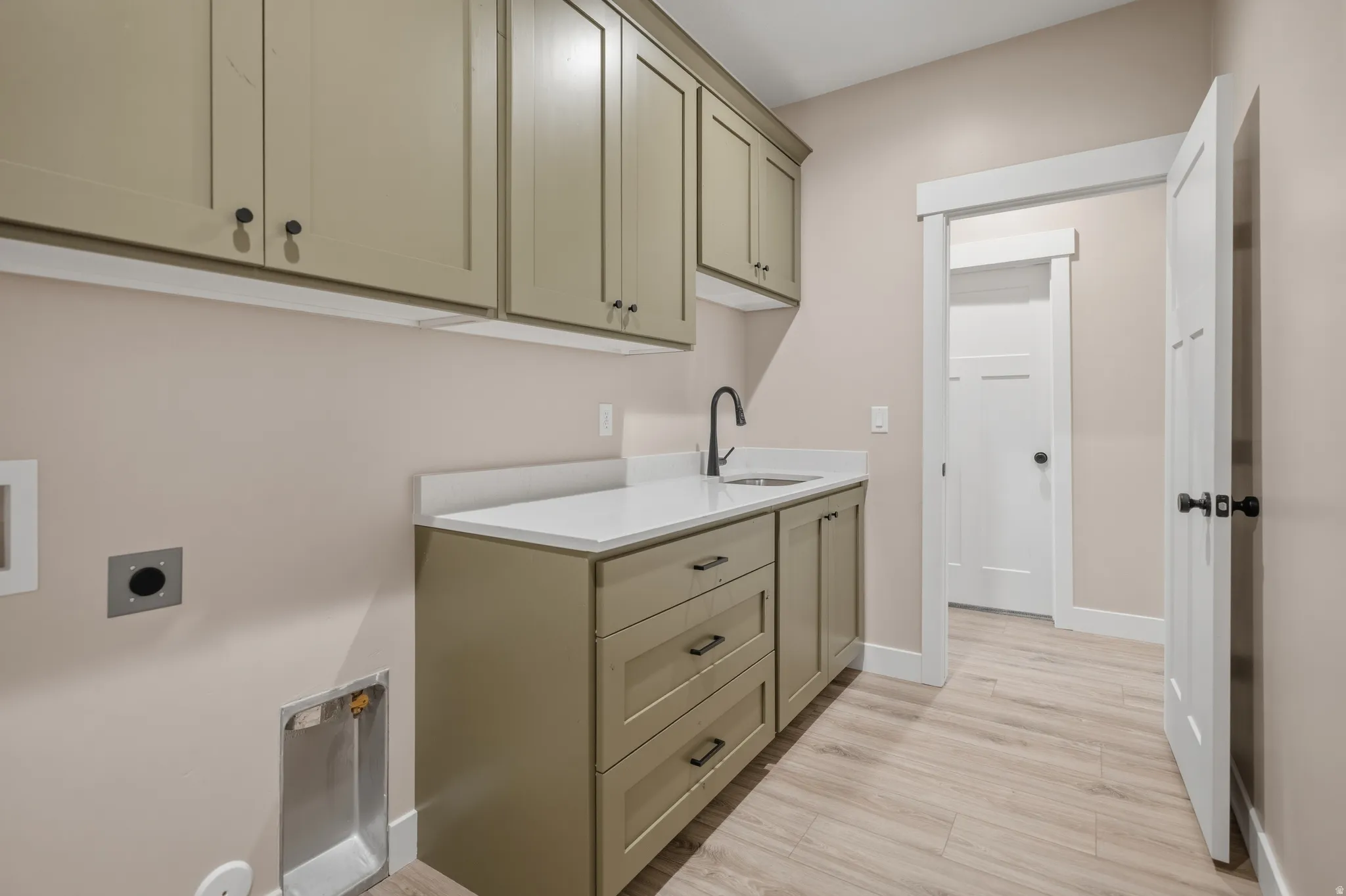 Laundry room featuring cabinet space, light wood-type flooring, hookup for an electric dryer, and hookup for a washing machine