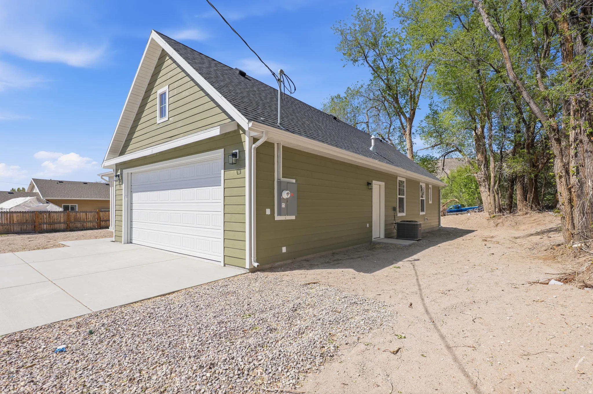View of side of home featuring driveway and roof with shingles