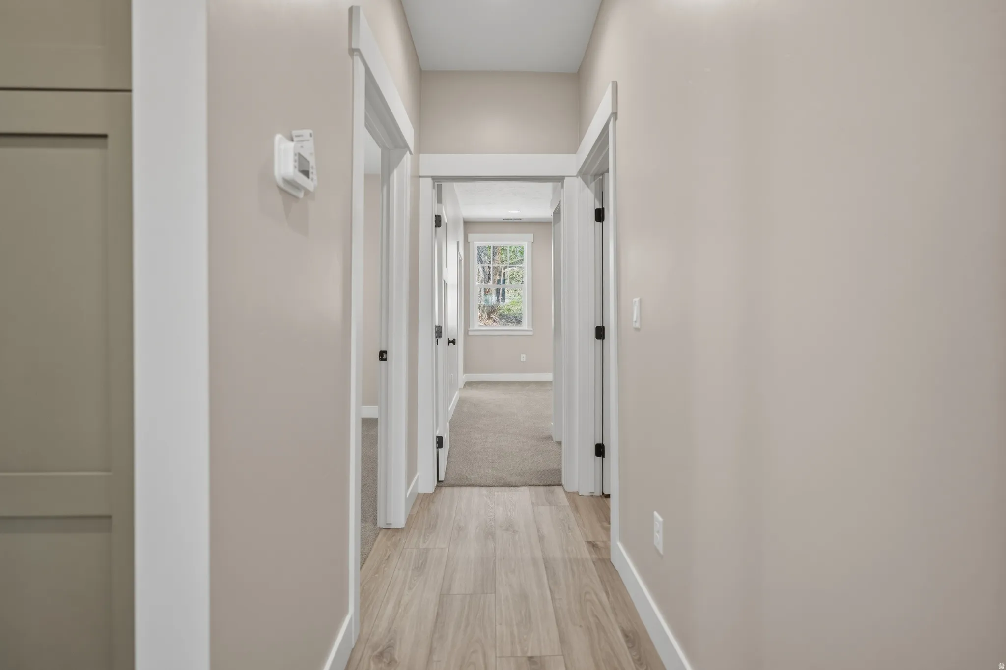 Corridor with baseboards and light wood-type flooring