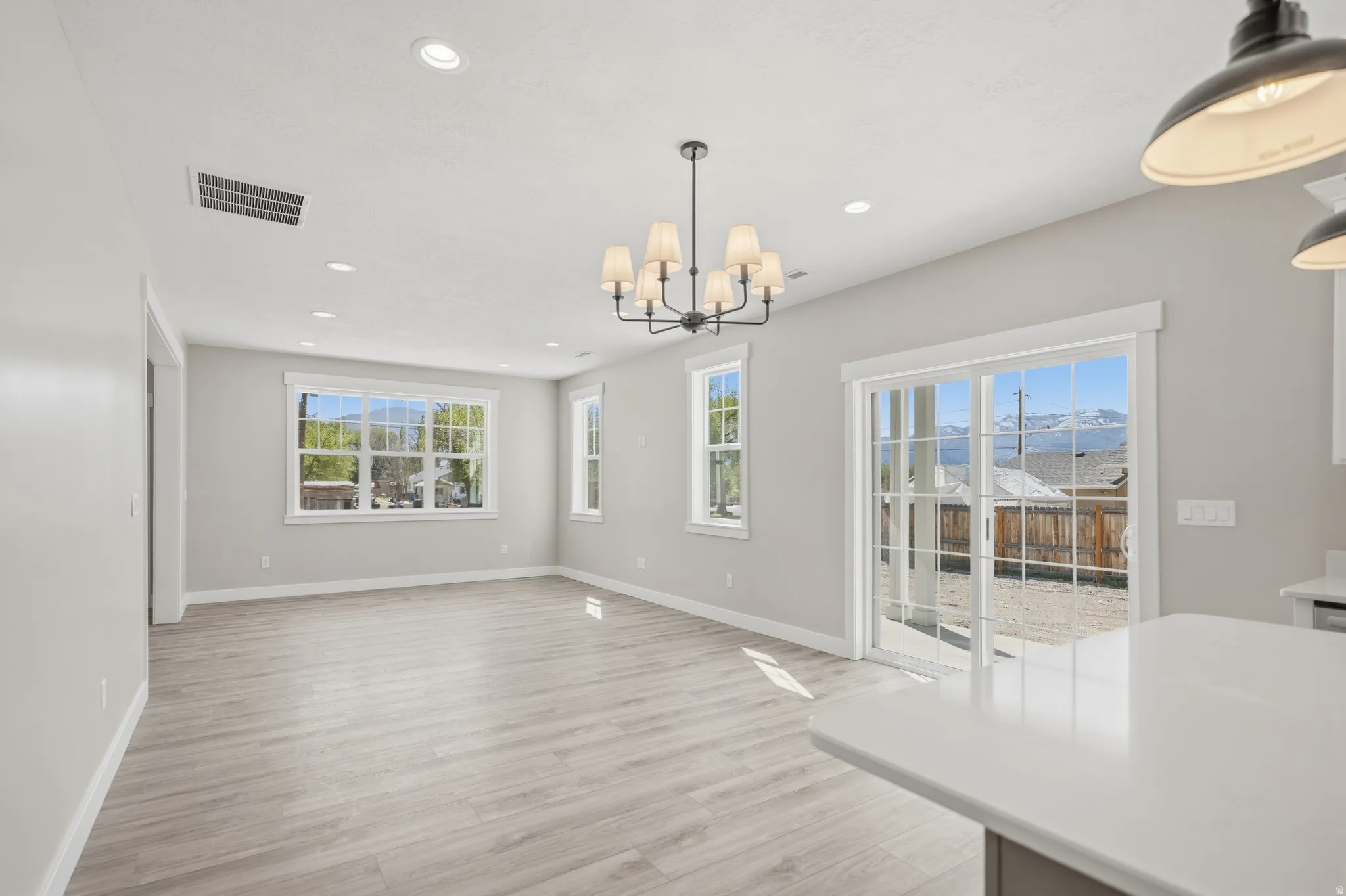 Unfurnished dining area with light wood finished floors and suspended lighting