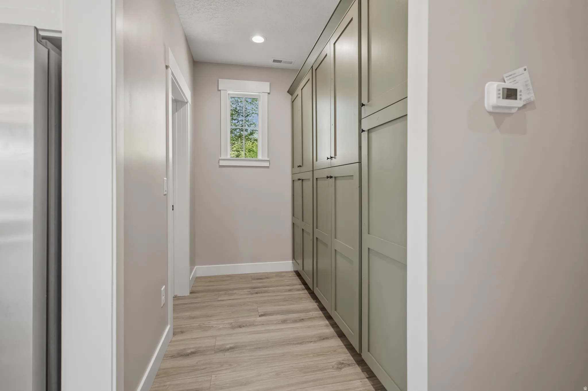 Corridor featuring light wood finished floors and recessed lighting