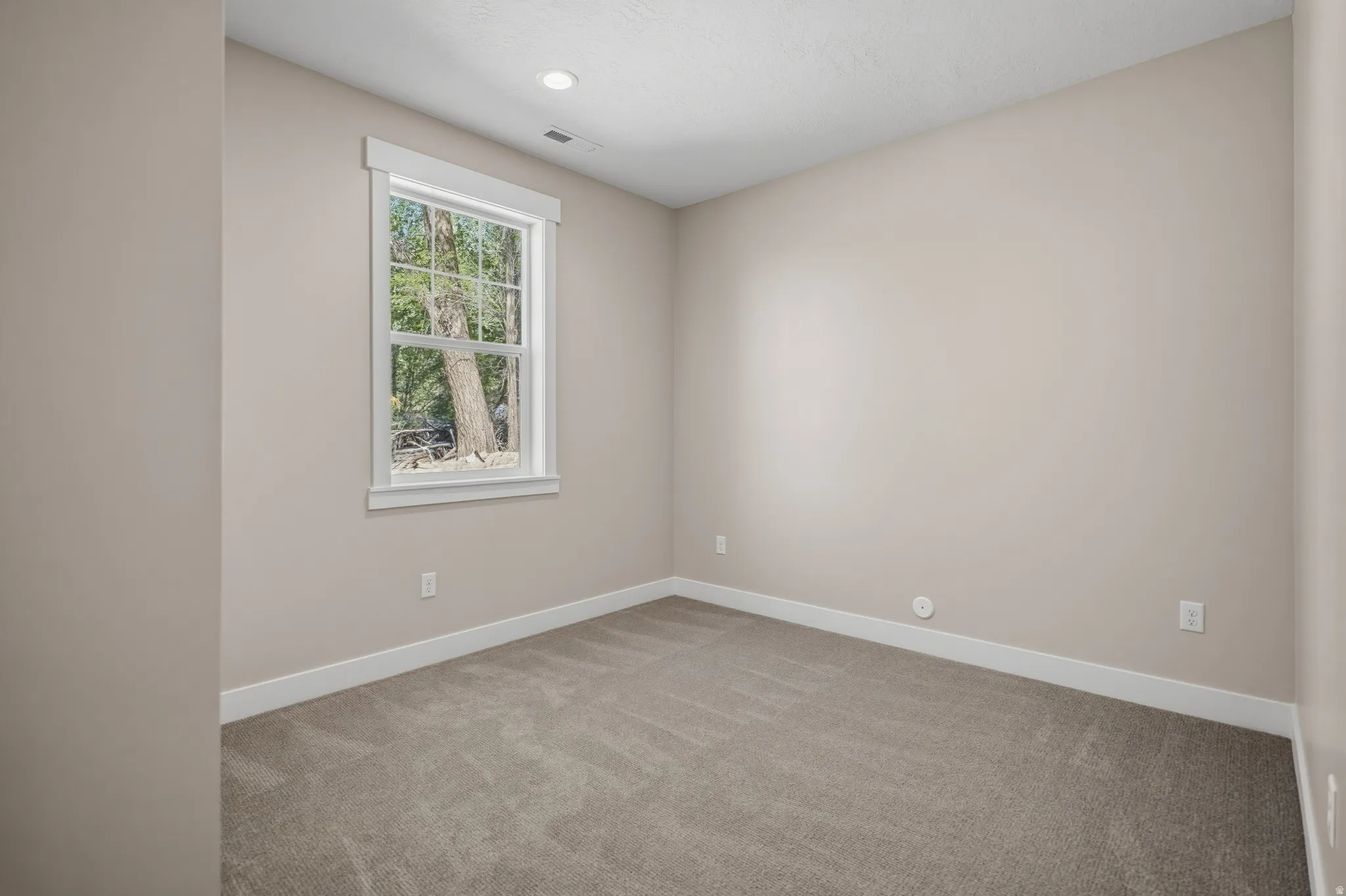 Unfurnished room featuring light carpet and baseboards