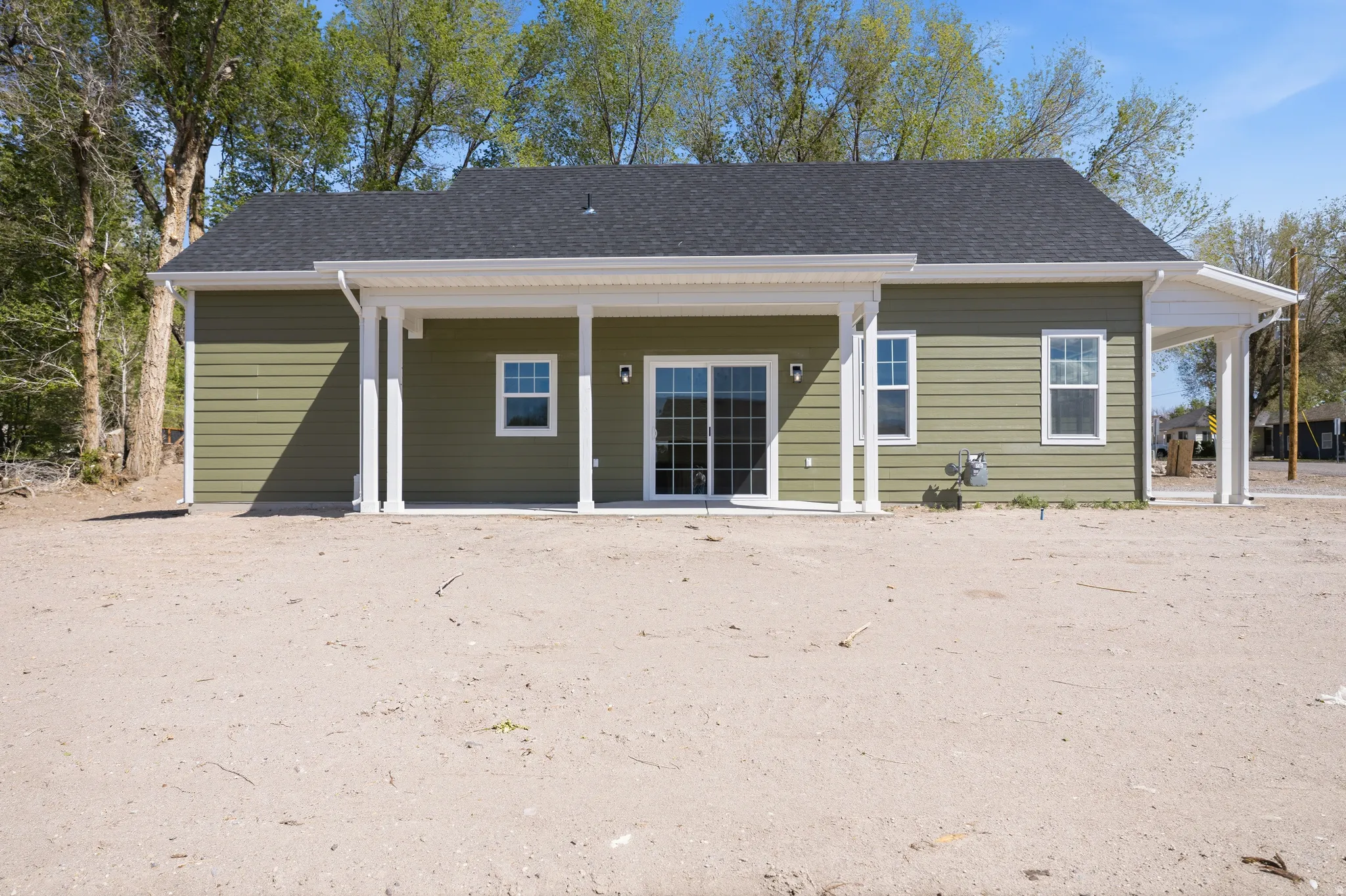 Back of property with roof with shingles and a patio area