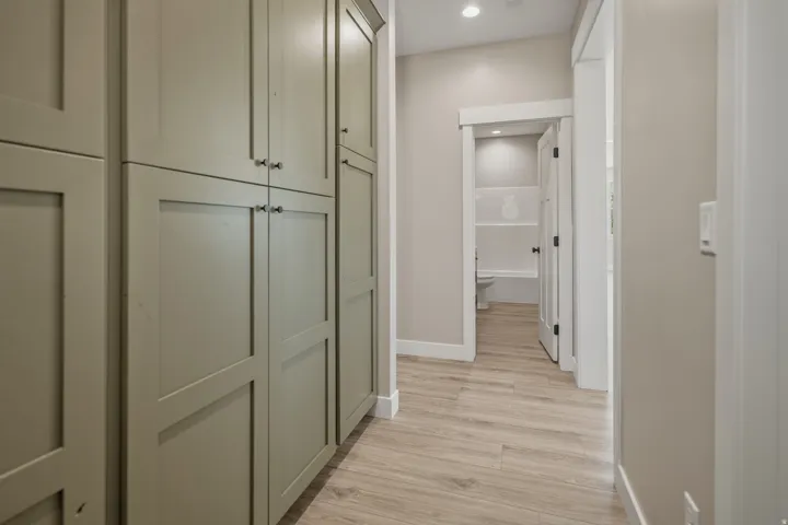 Hallway with light wood finished floors and recessed lighting