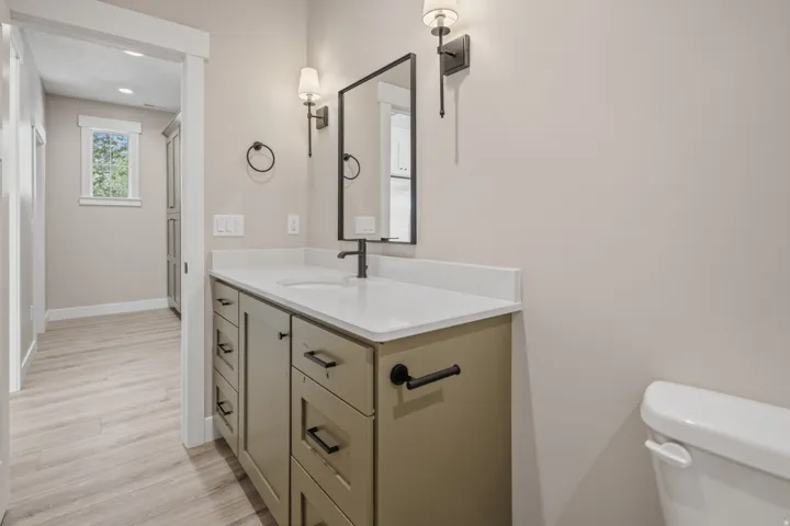Half bathroom with vanity, light wood finished floors, and recessed lighting