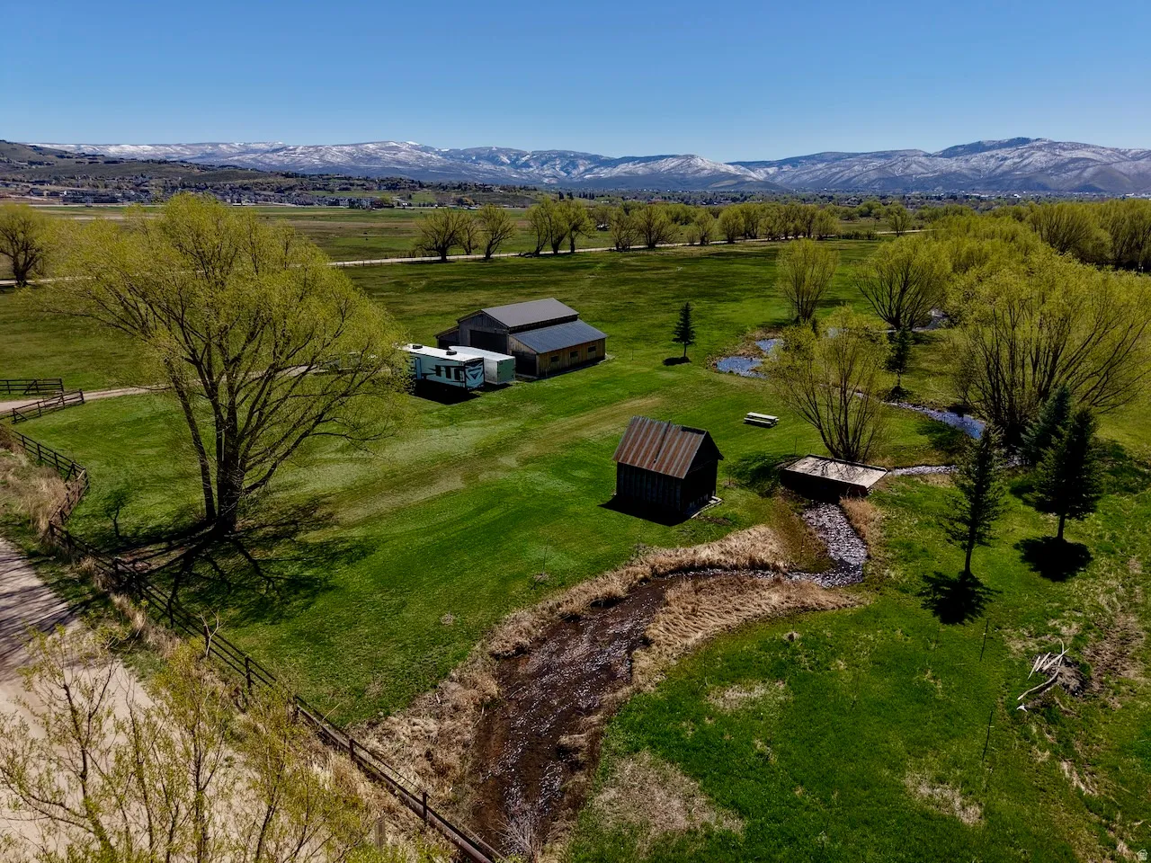 Aerial view of sparsely populated area with a pastoral area and a mountain backdrop