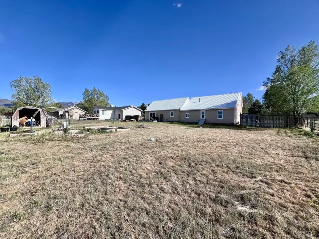 Rear view of house featuring a metal roof and a fenced backyard