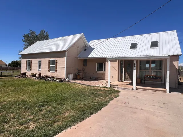 Metal roof with skylights, covered front porch, and exterior wood shutters
