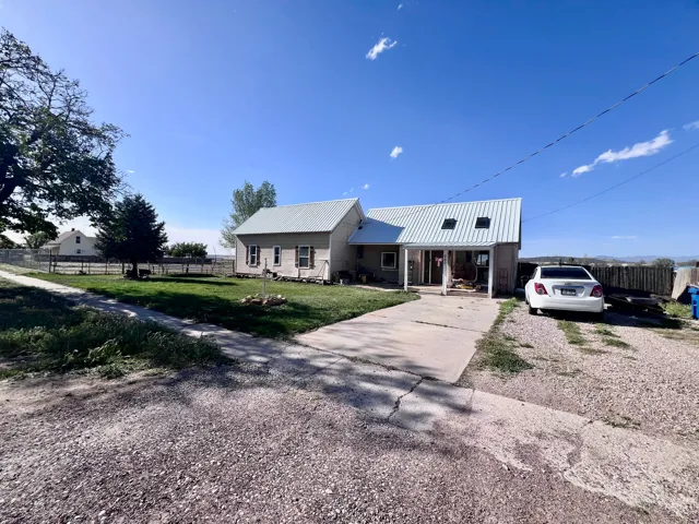Ranch-style home with covered porch, a metal roof, and concrete driveway